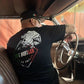 Mexican male inside of A classic car, wearing a side hustles build empires shirt. the shirt is A Bella canvas 3001 c shirt with a De-constructed Mexican flag, screen printed graphic.